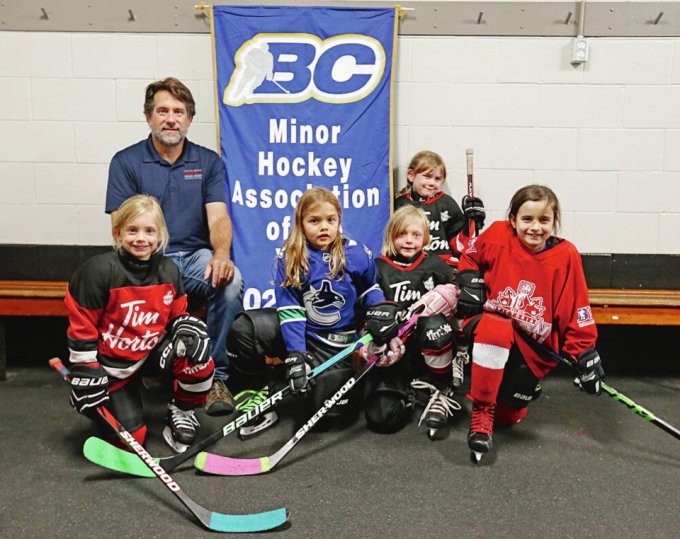 Ian Fleetwood, president of the Capital Region Female Minor Hockey Association, with players, from left, Baylor Kreczmer, 5, Hadley Vanderdonck, 7, Lizellle Gamsby, 7, Selena Taylor, 6, and Everly Sundher, 7, before a on-ice session at Pearkes arena. ADRIAN LAM, TIMES COLONIST
